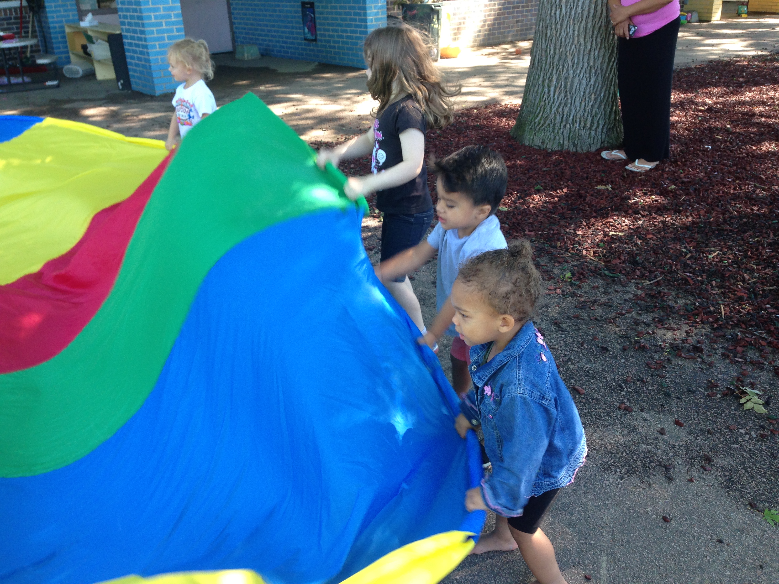 Children playing with colorful parachute